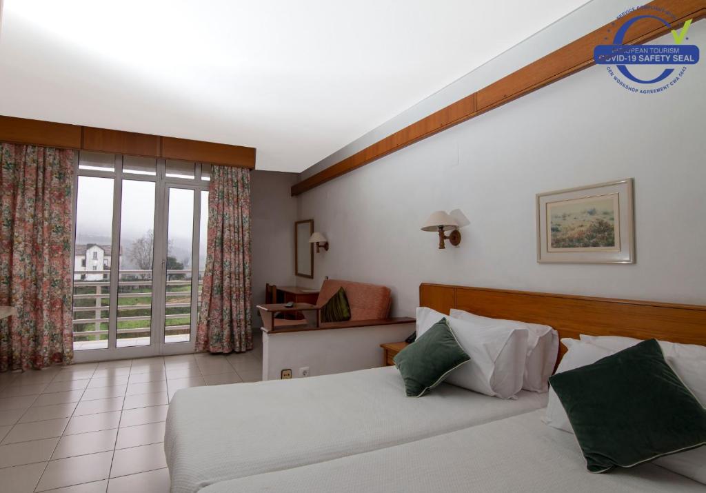 a hotel room with a bed and a balcony at Pantanha Studio by Trip2Portugal in Canas de Senhorim