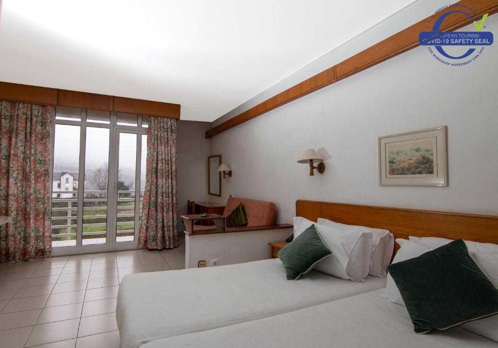 um quarto de hotel com uma cama e uma varanda em Pantanha Studio by Trip2Portugal em Canas de Senhorim