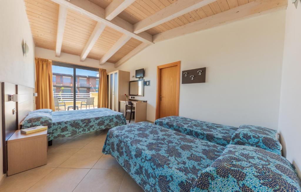 a hotel room with two beds and a television at Residence Renadoro in Cervia