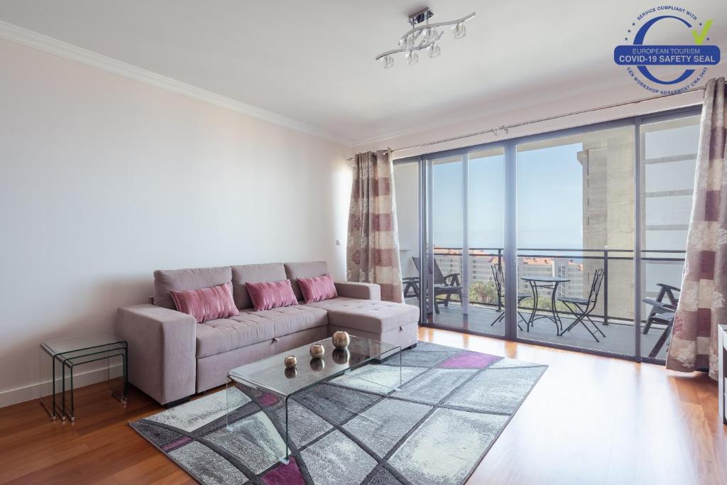sala de estar con sofá y balcón en Elegant Apartment with Sea Views by Trip2Portugal, en Funchal