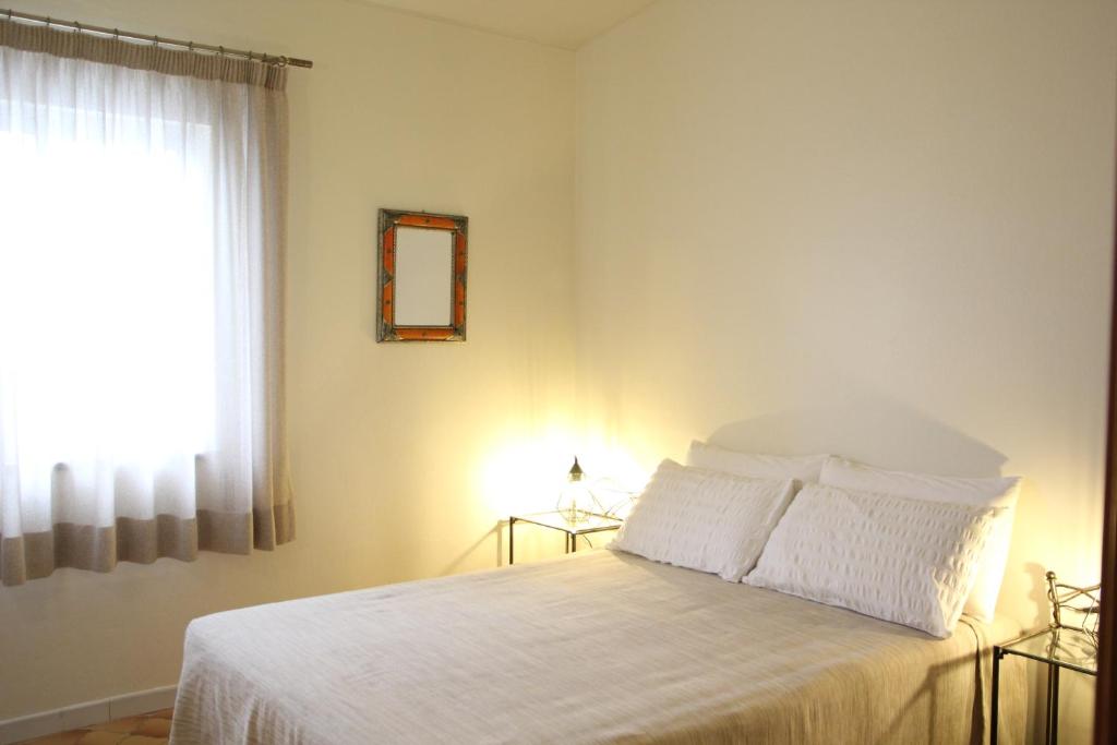 a bedroom with a bed with white sheets and a window at Angela Guest House in Lagos