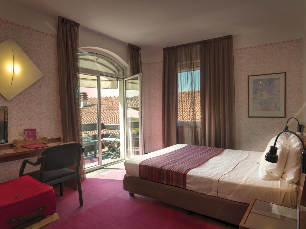 Postel nebo postele na pokoji v ubytování Cangrande Hotel
