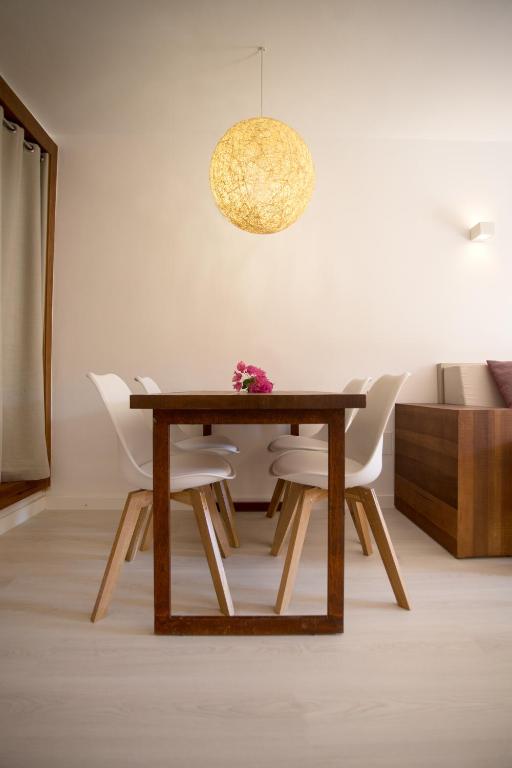 a dining room with a wooden table and white chairs at Insotel Club Tarida Playa in Cala Tarida