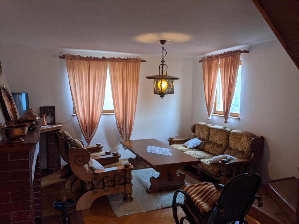 a living room with a table and a couch at Village Home - Kuca u prirodi in Tešanj