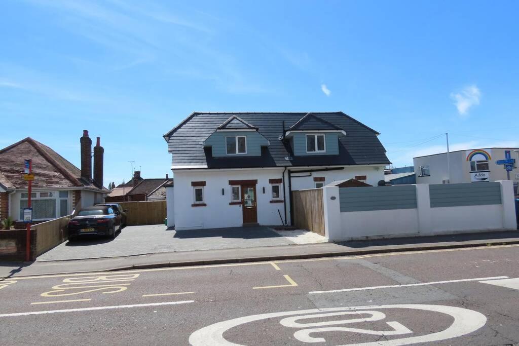 a house on the side of a street with a parking lot at 3 Bedroom Detached Beach House Poole in Poole