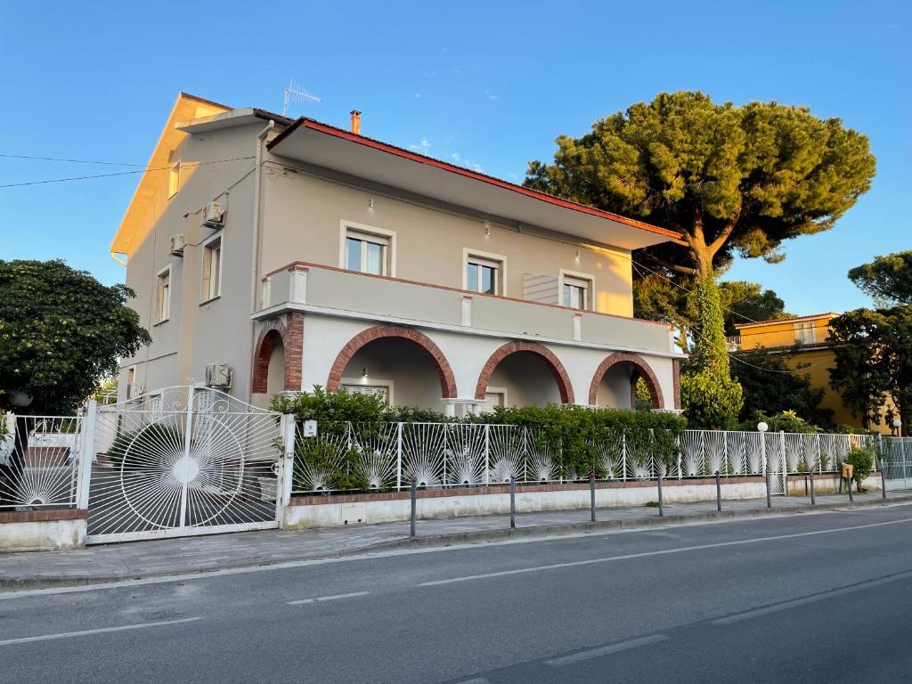 ein Haus an der Seite einer Straße mit einem Zaun in der Unterkunft Affittacamere Villa Paestum in Paestum