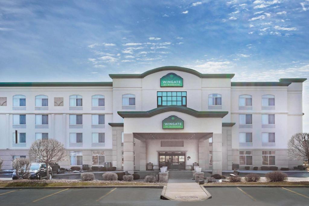 un grande edificio bianco con un cartello sopra di Wingate by Wyndham Tinley Park a Tinley Park