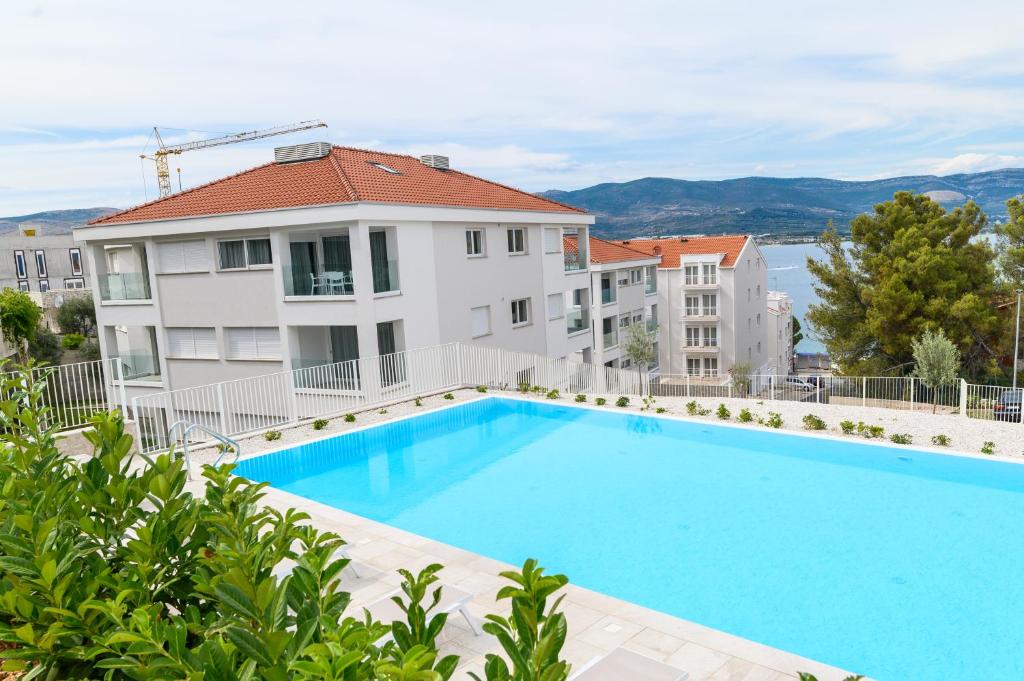 a large swimming pool in front of a building at Malo More Resort in Trogir