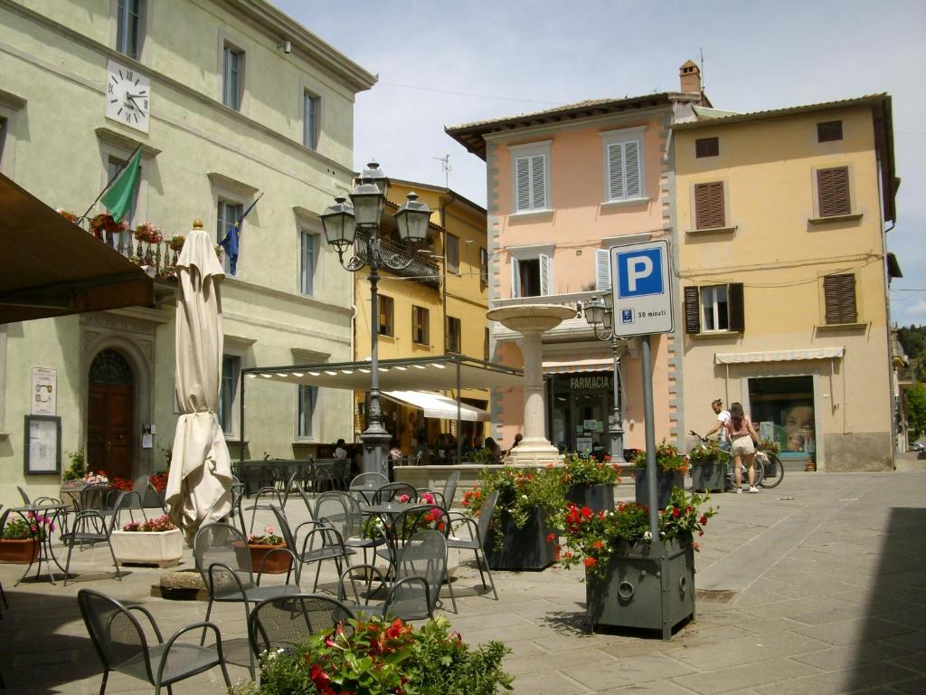 un patio avec des chaises et des tables ainsi qu'un panneau de stationnement dans l'établissement La Poventa, à Tuoro sul Trasimeno