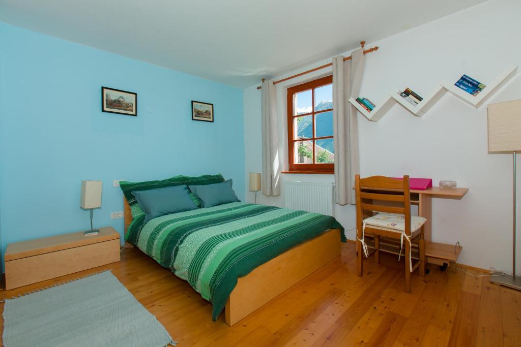 um quarto com uma cama, uma secretária e uma janela em Thirsty River Apartments em Bovec