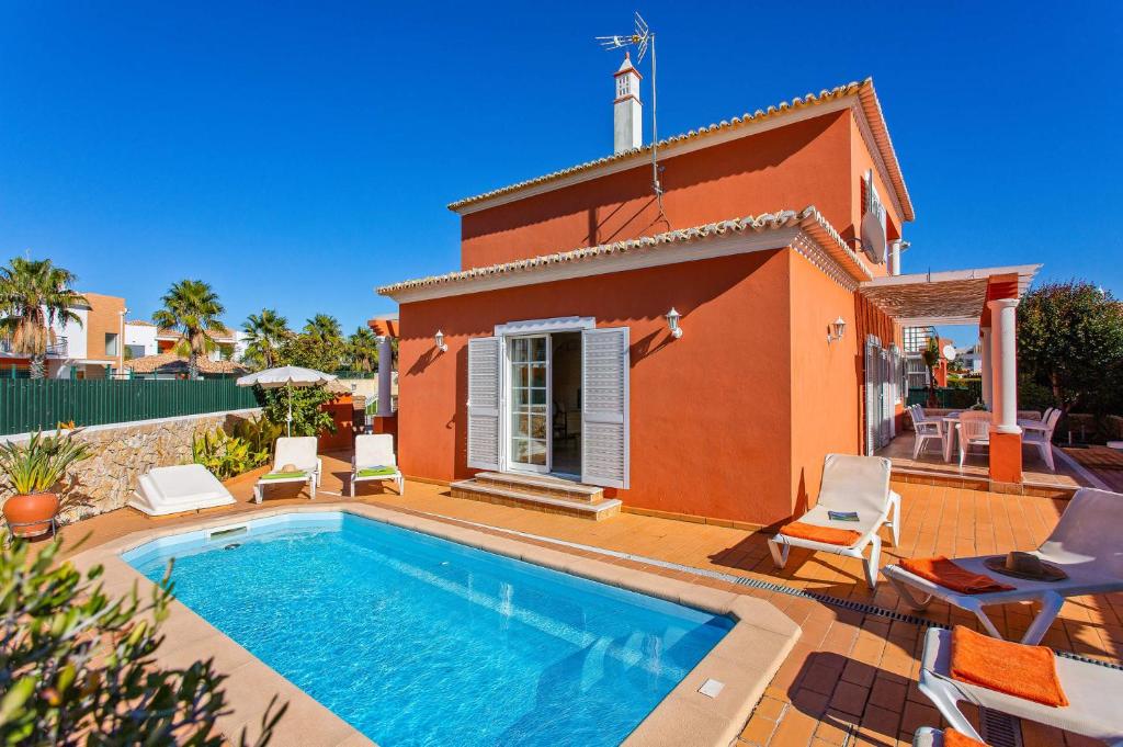 a villa with a swimming pool in front of a house at Villa Pera by Villa Plus in Pêra