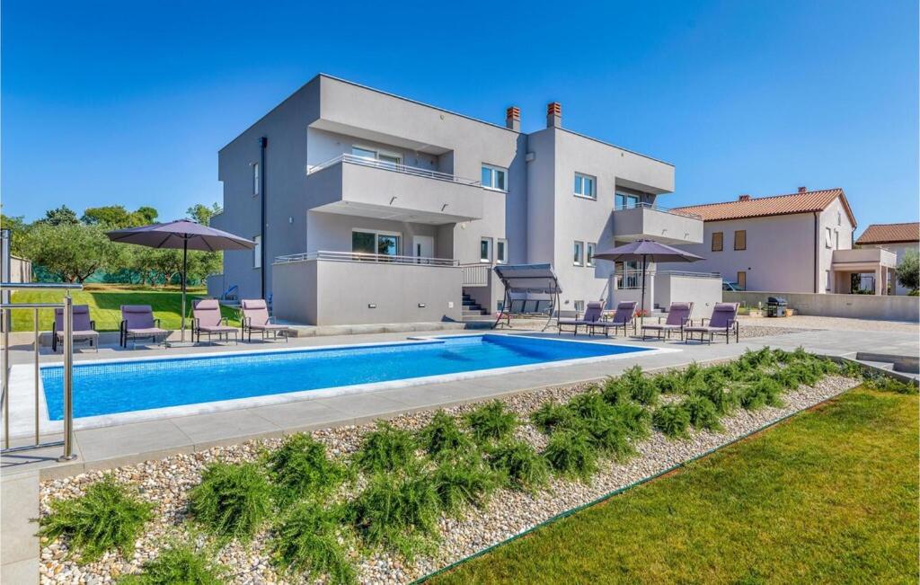 une villa avec une piscine en face d'une maison dans l'établissement Villa Grande T&D, à Pula