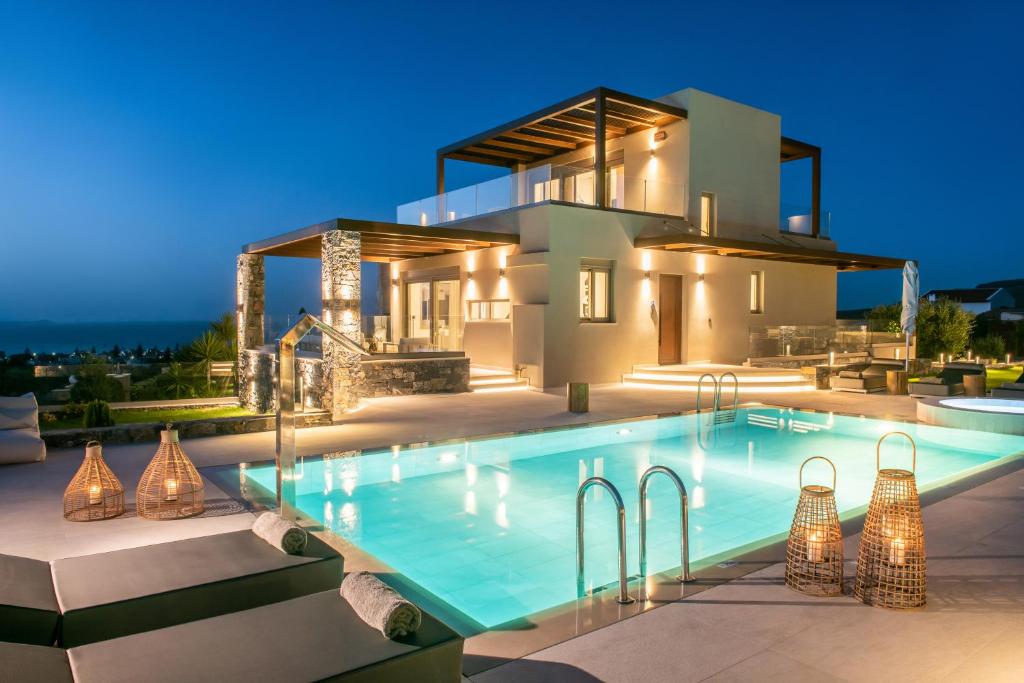 a villa with a swimming pool in front of a house at Kymo Instyle Villa - Sea view Private pool Jacuzzi in Kokkini Khanion