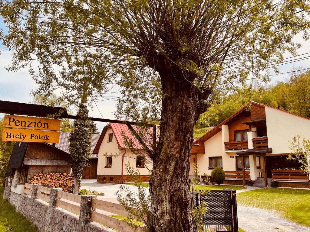 a large tree in front of a building at Penzion Biely Potok in Terchová