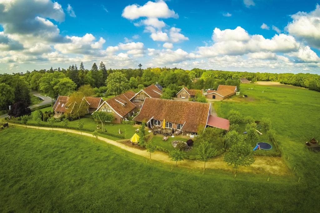 een luchtzicht op een huis in een groen veld bij Hotel en B&B Erve Bruggert in Haaksbergen