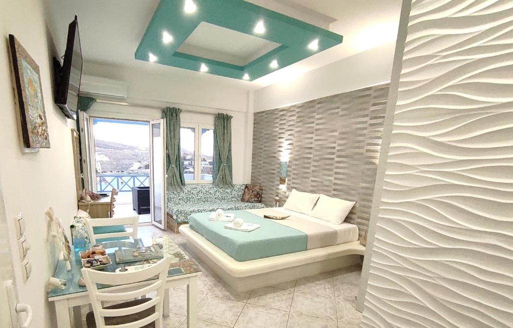 a bedroom with a bed and a desk in a room at Fantastic View Kythnos suites & studios in Kithnos