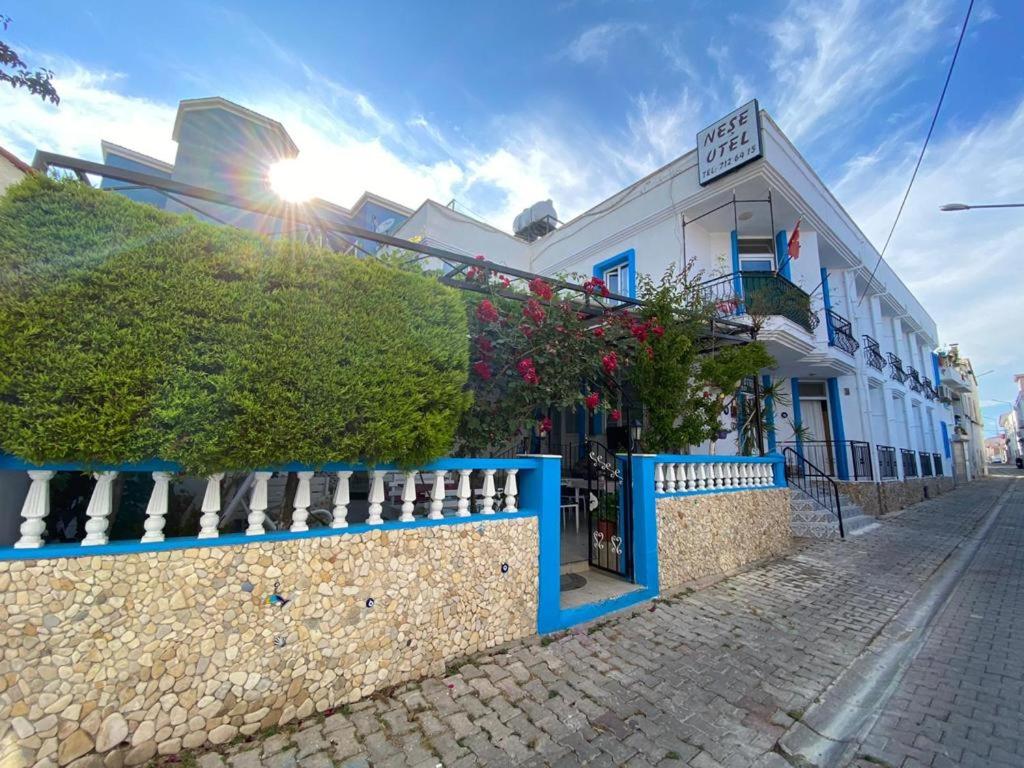 un bâtiment avec une clôture bleue dans une rue dans l'établissement Nese Hotel, à Çeşme