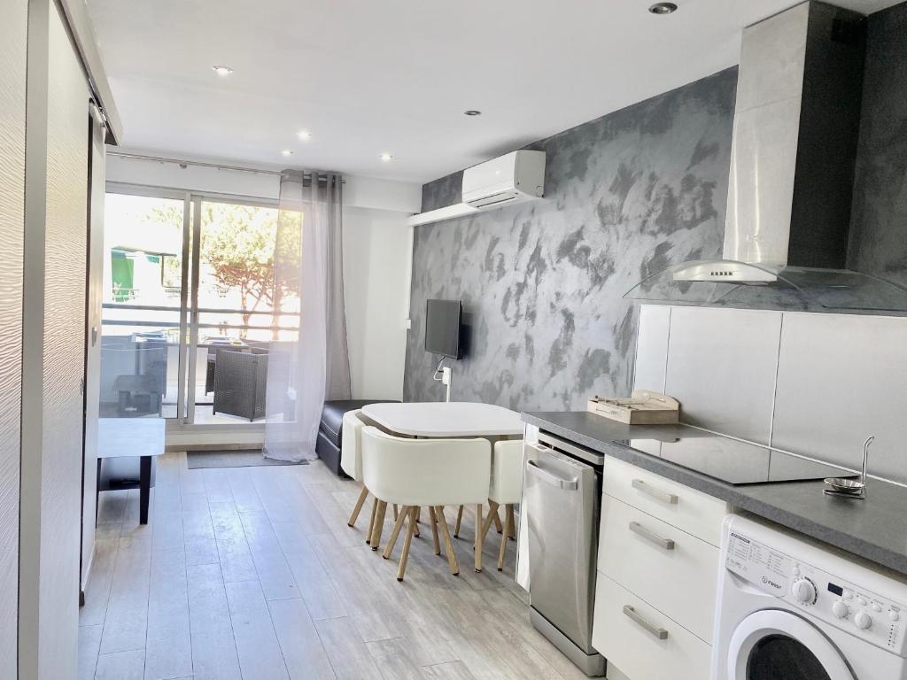a kitchen with a sink and a table in a room at L'HERMITAGE - Studio moderne - Piscine - Ascenseur - Quart Golf in La Grande-Motte