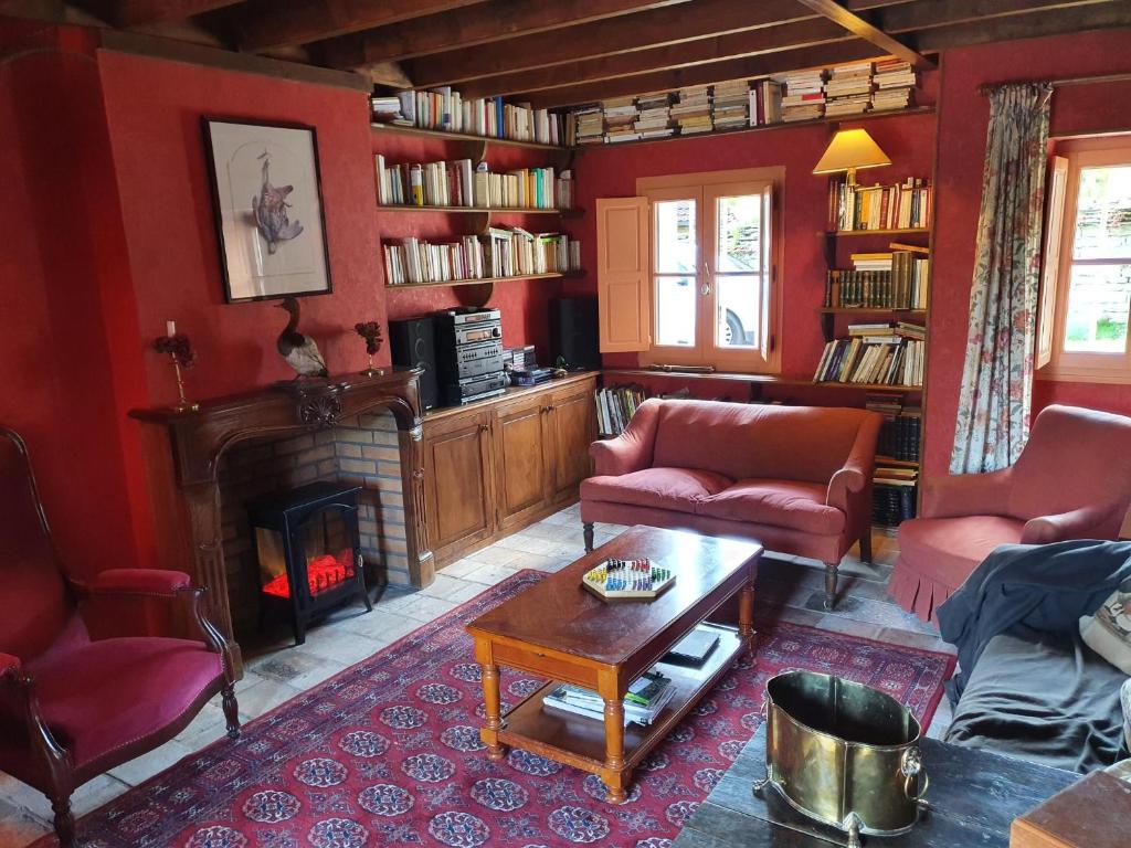 uma sala de estar com lareira e paredes vermelhas em maison authentique 2 à 8 personnes em Uncey-le-Franc