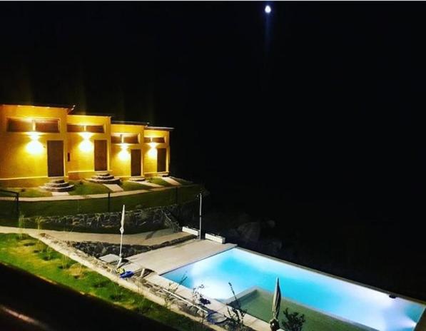 une maison avec une piscine la nuit dans l'établissement Posada Tampu Kuntur, à San Antonio de Arredondo