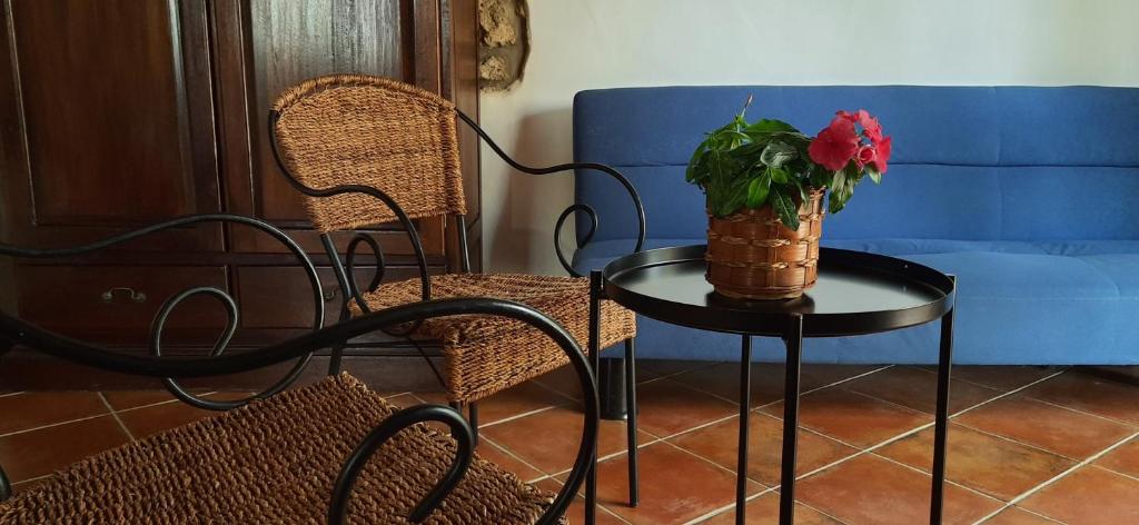 a table with a vase with a red flower on it at Casale Ginisara in Castellammare del Golfo
