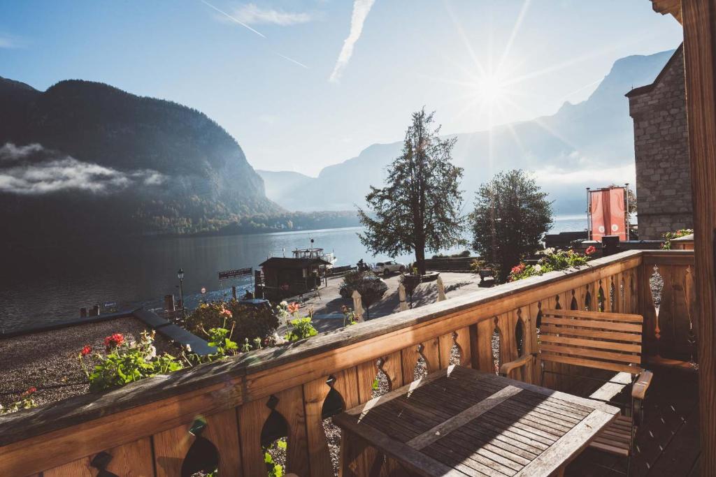 a wooden balcony with a bench and a view of a lake at Heritage Hotel Hallstatt in Hallstatt