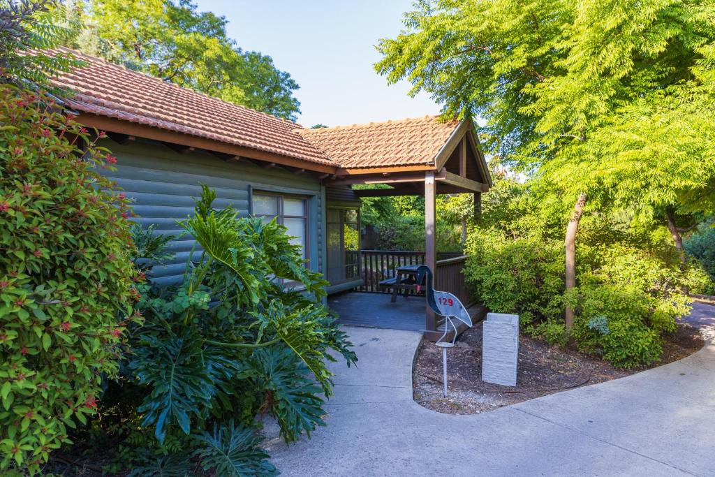 una casa con cenador y banco en un porche en Nofey Gonen Holiday Village, en Gonen