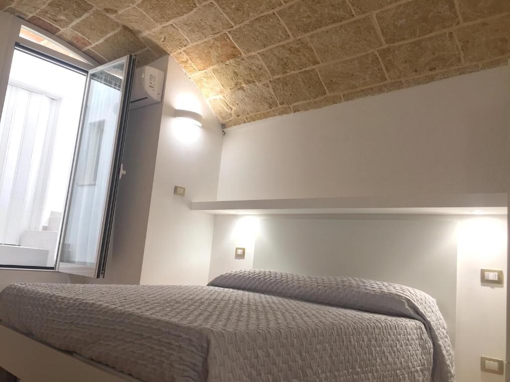 Schlafzimmer mit einem Bett mit Ziegeldecke in der Unterkunft Ugento Dimora in Ugento