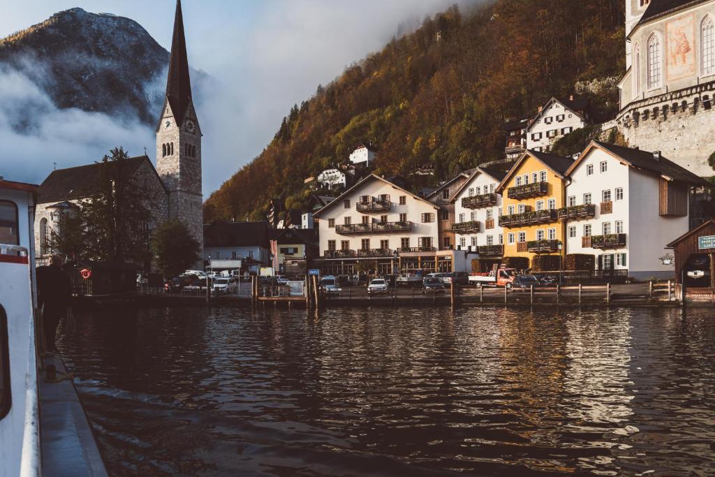 a small town next to a body of water with a church at Heritage Hotel Hallstatt in Hallstatt