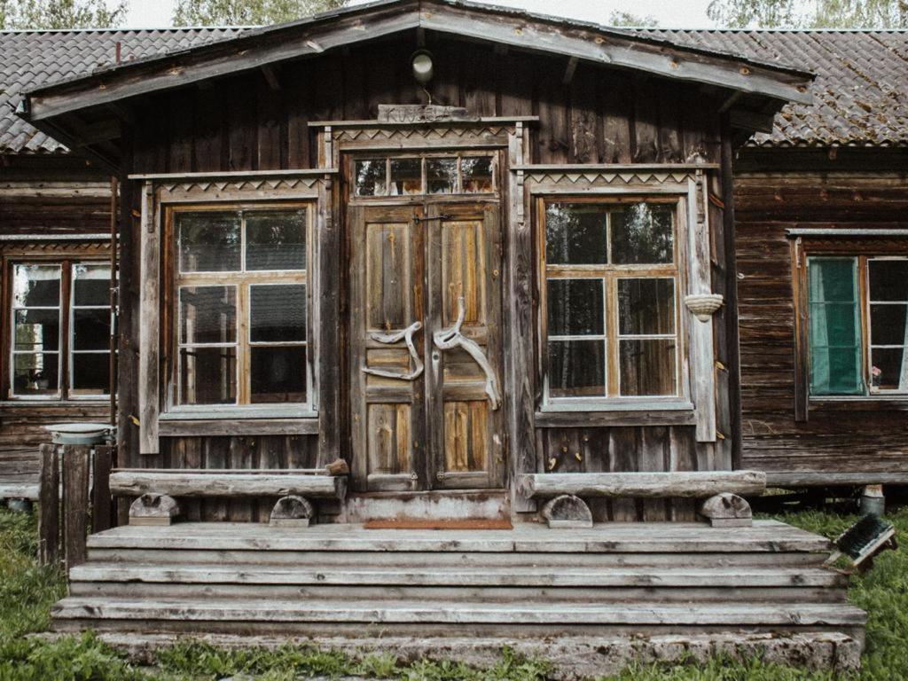 una casa antigua con dos ventanas y una puerta en Tarina-Aho, en Vuonislahti