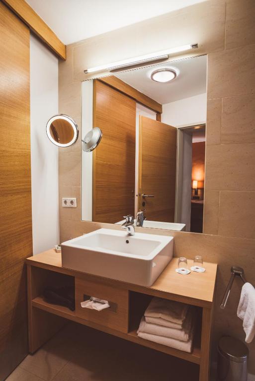 a bathroom with a sink and a large mirror at Heritage Hotel Hallstatt in Hallstatt