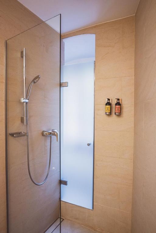 a shower with a glass door in a bathroom at Heritage Hotel Hallstatt in Hallstatt