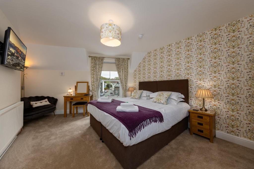 a bedroom with a large bed and a desk at Portland House in Keswick