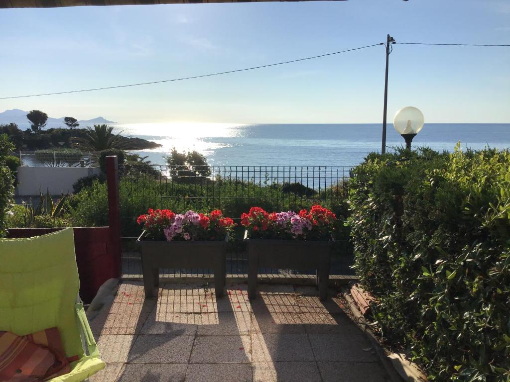 een patio met bloemen en uitzicht op de oceaan bij Face à la mer in Saint-Aygulf