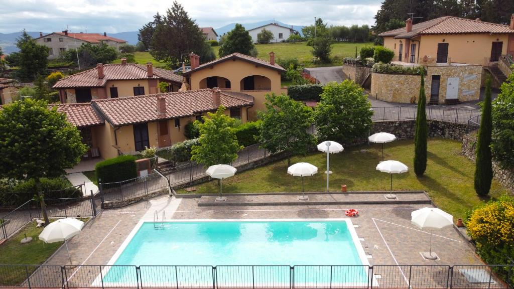 a swimming pool in a yard with umbrellas at Sweet Home Contignano in Contignano