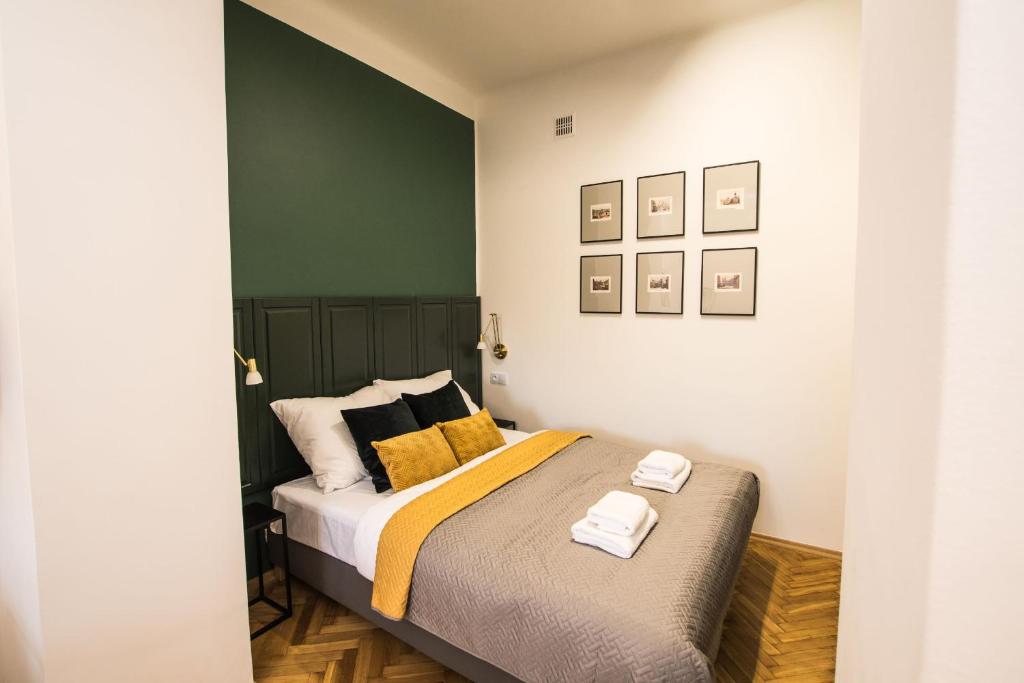 - une chambre avec un lit doté d'oreillers jaunes et noirs dans l'établissement Apartamenty FRETA4 Warsaw Old Town Apartments Warszawa Stare Miasto, à Varsovie