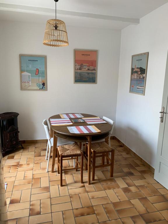 a dining room with a table and chairs at Appartement la corde a linge Gruissan village avec terrasses in Gruissan