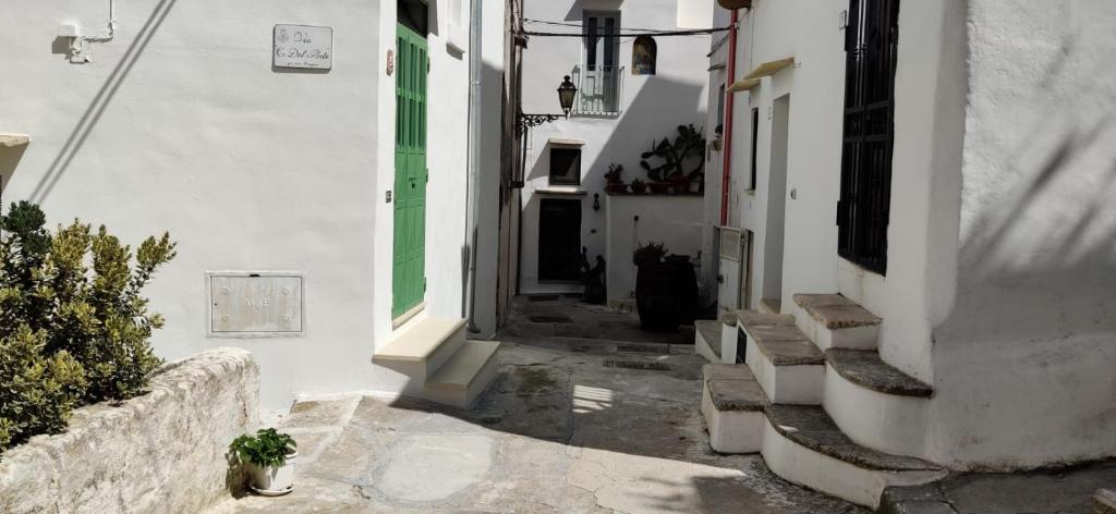 eine Gasse mit weißen Gebäuden und einer grünen Tür in der Unterkunft Matino Antico Borgo in Matino