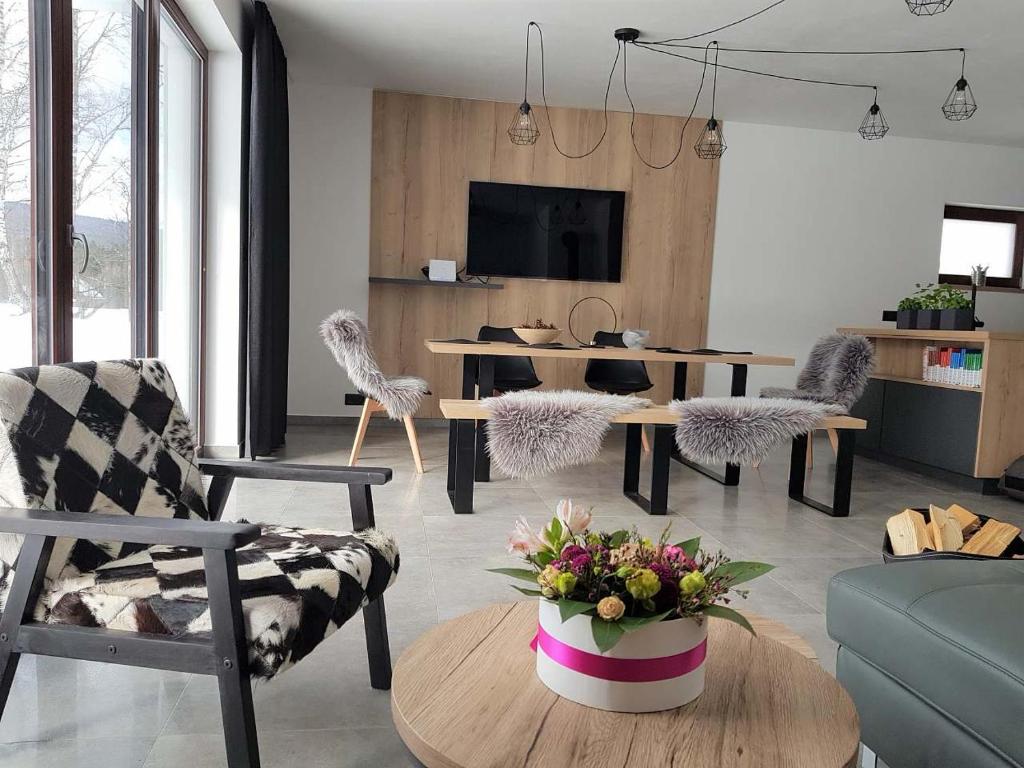 uma sala de estar com mesa e cadeiras em Apartmán Pod Hochfichtem em Nová Pec