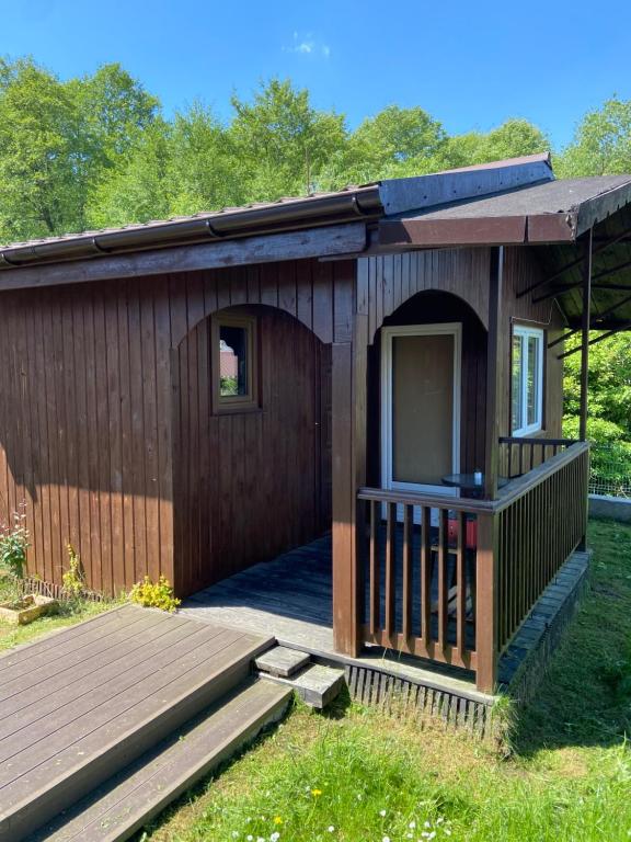 a small building with a porch and a deck at Domek wakacyjny in Charzykowy