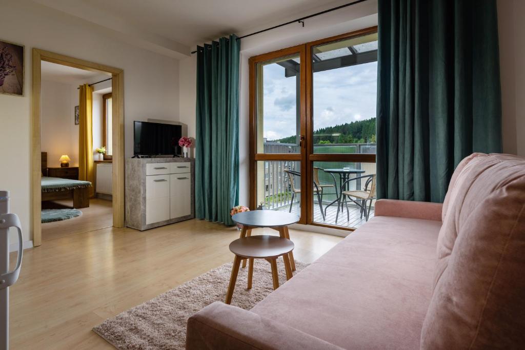 a living room with a couch and a balcony at Apartman SIESTA*** in Liptovský Mikuláš