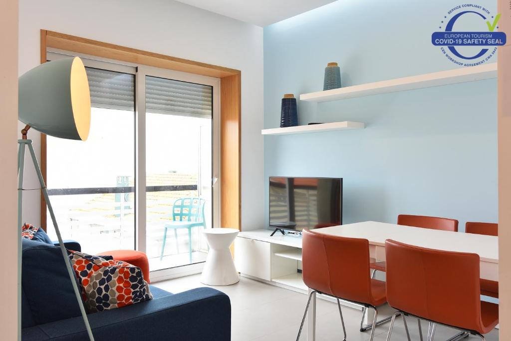 フィゲイラ・ダ・フォズにあるMaestro Apartment by Trip2Portugalのリビングルーム(テーブル、椅子、デスク付)