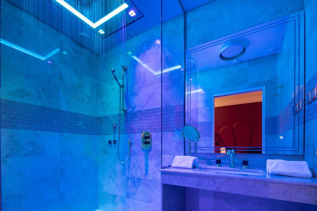 Une Salle De Bain Avec Des Néons Et Un Lavabo Avec Un Miroir Qui Dit 'néon