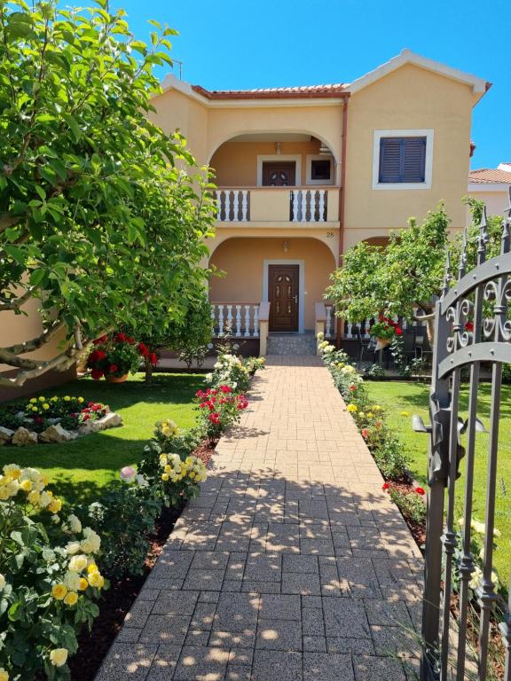 a house with a walkway in front of a yard at Apartman Tea in Privlaka