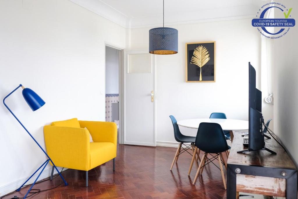 リスボンにあるBarao Apartment by Trip2Portugalのリビングルーム(黄色い椅子、テーブル付)