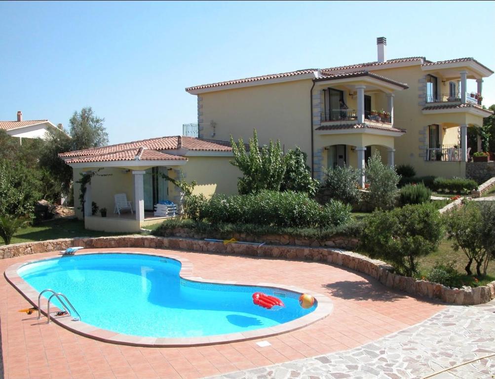 una casa con piscina frente a una casa en Residence Agrifoglio, en Monte Petrosu