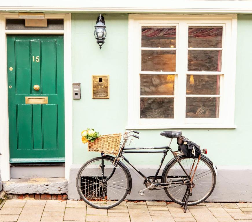 a bike parked in front of a house with a green door at Tower House Guest House in Oxford