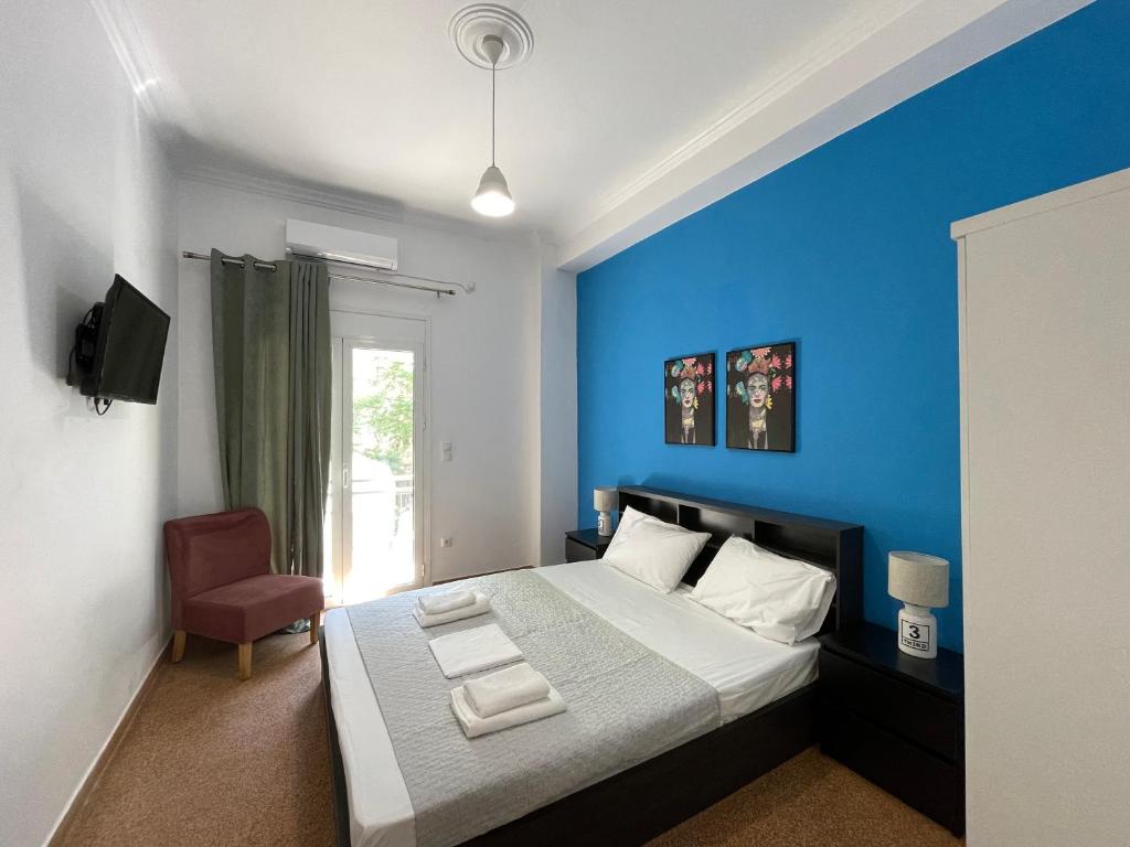1 dormitorio azul con 1 cama y 1 silla en SOHO Charming 55sqm apt in Athens, en Atenas
