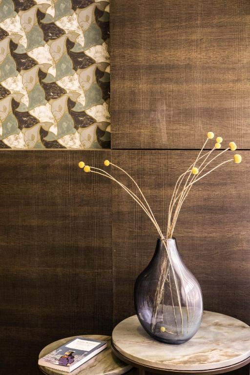 a vase with flowers in it sitting on a table at Hotel American-Dinesen in Venice