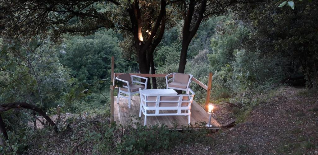 2 sillas y una vela sentada en una terraza de madera en Gîtes chez Daniel "Cevennes 2", en Mars